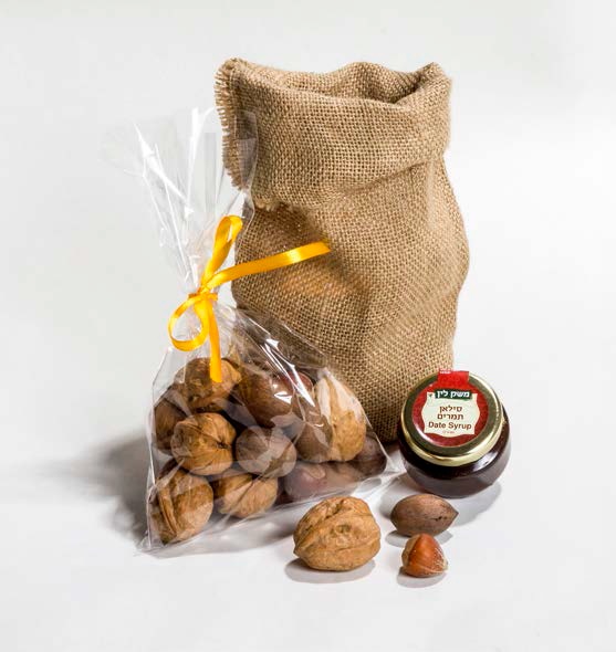 מיקס אגוזים - מארז שק יוטה דקורטיבי, המכיל מיקס אגוזים בקליפתם :אגוזי מלך, אגוזי פקאן ובונדוקים, 250 גרם, סילאן תמרים/מעדן 60 גרם.