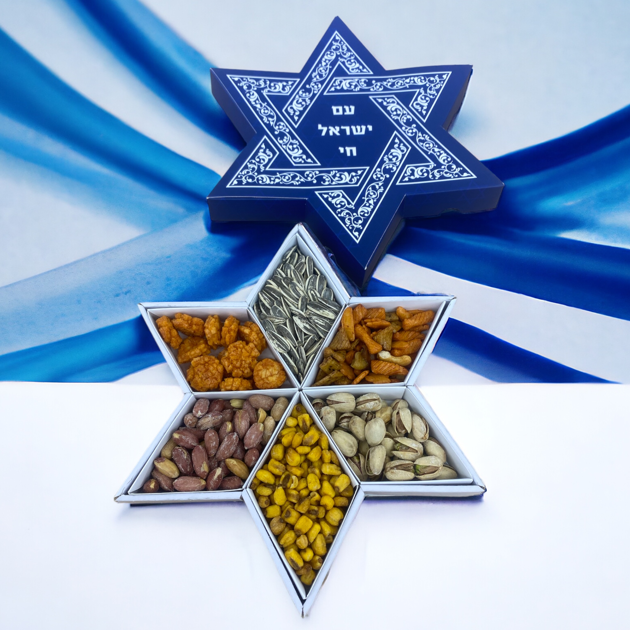 מארז מגן דוד 500 - 
מארז בצורת מגן דוד במשקל של כ 400-500 גרם המכיל פיצוחים: גרעינים שחורים, בוטנים, פיסטוק, תירס קלוי, פריכיות אורז פיקנטי, מנצ